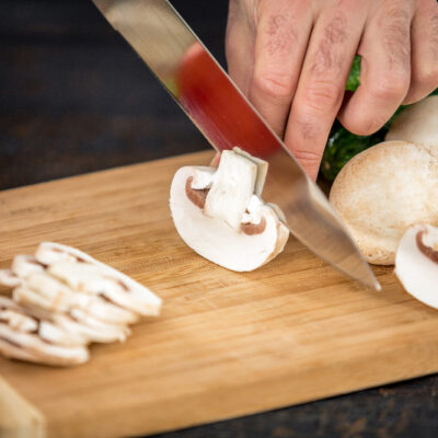 male-hands-cutting-vegetables-salad